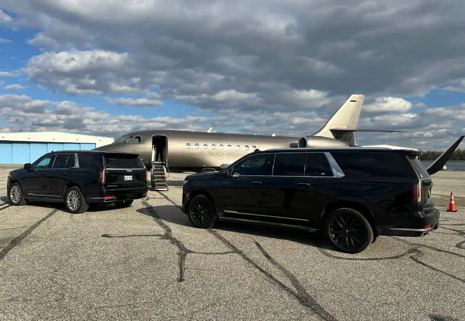Luxury Cadillac Escalade SUVs at a private airport in front of a private jet, providing executive transportation and exclusive transfers in Washington, D.C